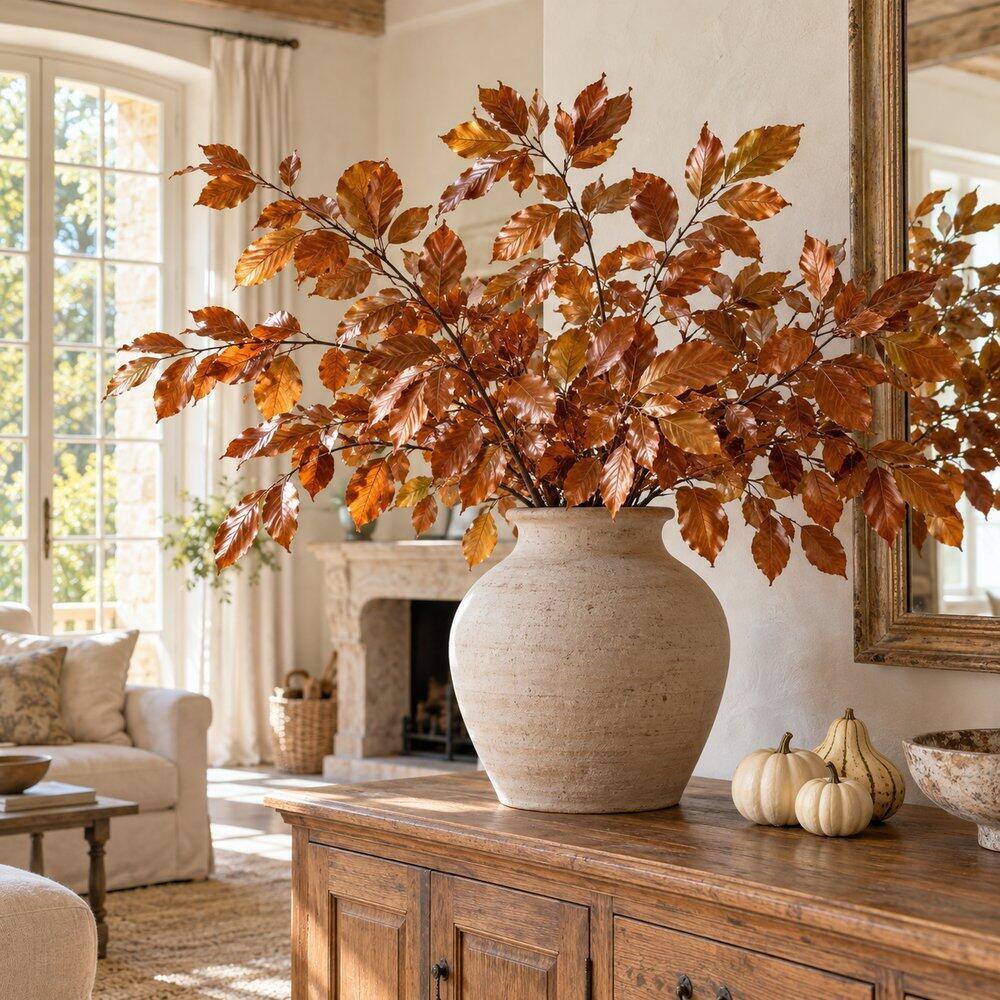Décoration d’automne inspirée par la nature Branches cuivrées préservées disposées dans un grand vase en grès au salon