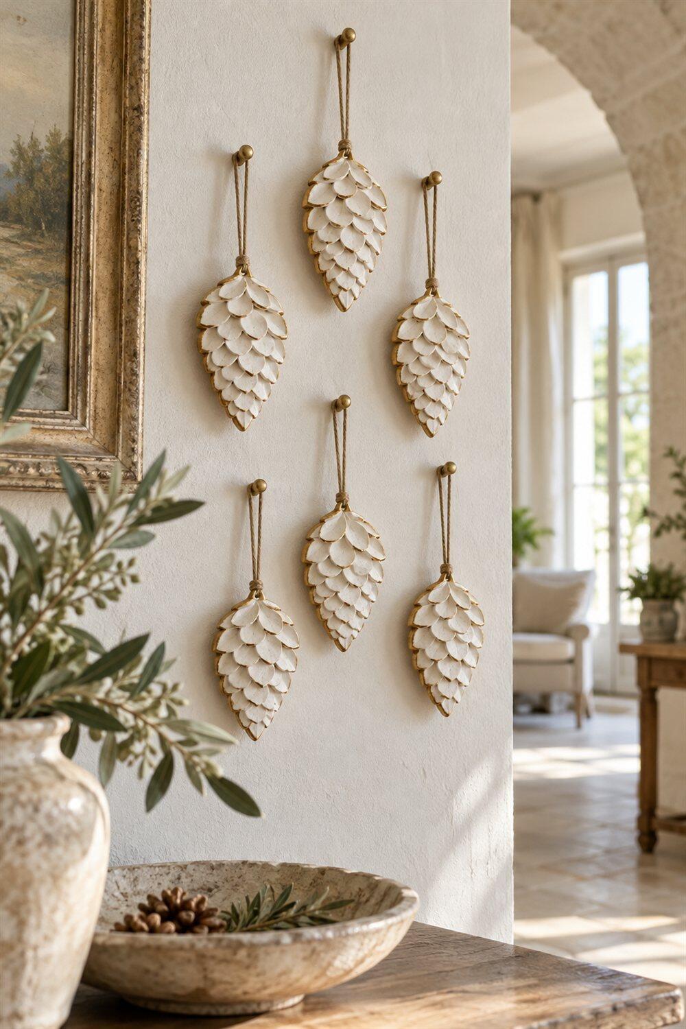 Petites pommes de pin en argile blanche suspendues avec des contours dor&eacute;s
